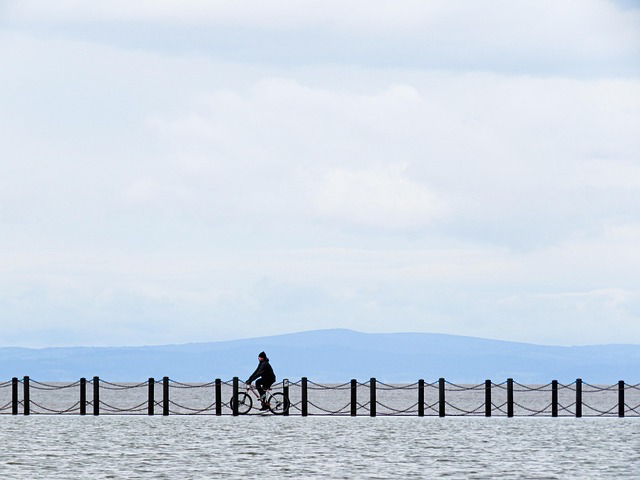 cyclist checking tyre pressure and brakes before ride Dublin Ireland